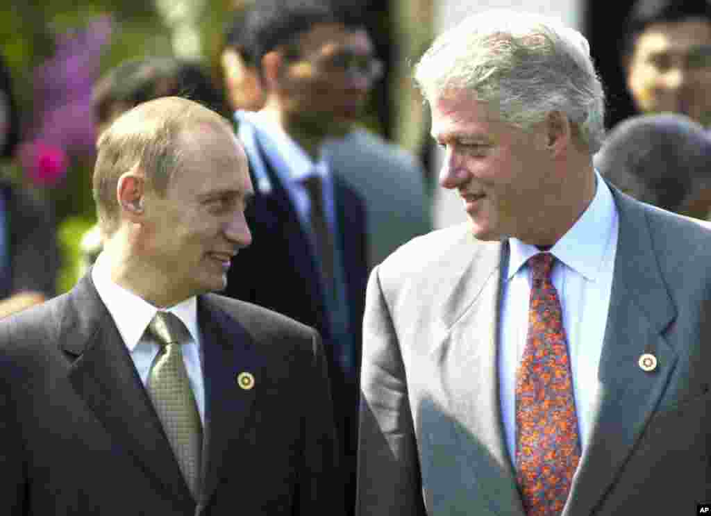 Bill Clinton și Vladimir Putin în iulie 2000, la Okinawa, Japonia, la o ceremonie de plantare de copaci la Bankokushinryokan sau „Podul către lume”, înaintea reuniunii Grupului celor Opt.