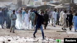 A supporter of the Islamist Tehrik-e Labaik party hurls stones toward police during a protest against the arrest of their leader in Lahore, on April 13.