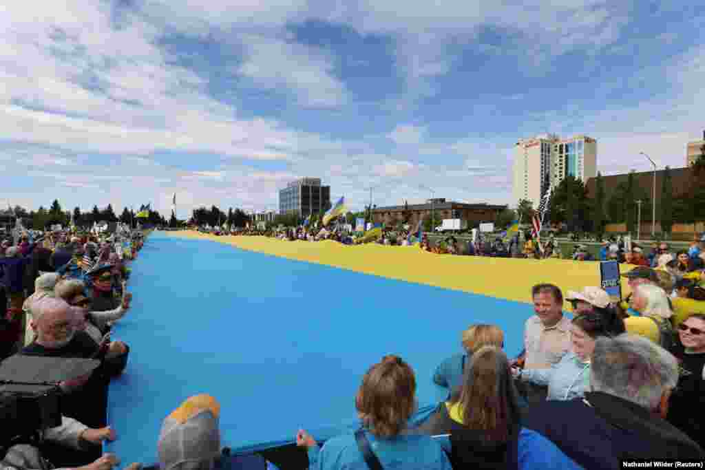 Мітингувальники з велетенським прапором України після того, як президент США Дональд Трамп заявив, що він і президент Росії Володимир Путін не дійшли згоди щодо вирішення війни Москви в Україні після майже тригодинного саміту в Анкориджі, Аляска, 15 серпня 2025 року