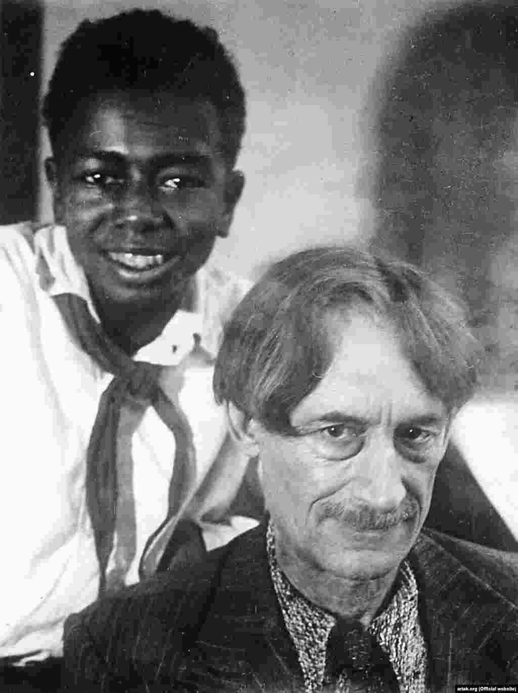 Французский писатель Анри Барбюс в 1928 году по приглашению Зиновия Соловьева приехал в «Артек». Именно Барбюс в свой приезд и стал первым из иностранных гостей и гостей вообще, принятых в почетные артековцы. После посещения лагеря писатель написал: «Артек» – настоящий рай, но рай земной, реальный, где жизнь детей трудящихся проходит в оздоровлении своих физических сил, приобретении знаний и спорте». На фото – Анри Барбюс и пионер-артековец по имени Джим