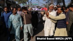 Relatives and locals carry the body of a man who was killed after an angry mob allegedly stoned him to death, in Khanewal district on February 13.