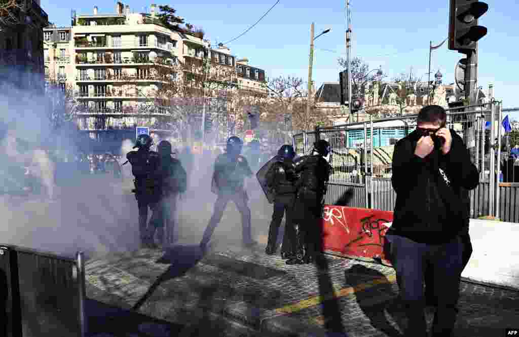 Демонстрант відвертається від сльозогінного газу на площі Італії в Парижі, 12 лютого 2022 року. Тим часом до столиці Франції продовжують прибувати протестувальники, які називають себе «Convoi de la Liberte» (Колона свободи). Тисячі протестувальників з усієї Франції, натхненні канадськими далекобійниками, які паралізували прикордонний рух із США, прямували 11 лютого авомобілями до Парижа. Деякі сподівалися заблокувати столицю, незважаючи на попередження поліції. Серед протестувальників є багато активістів, які борються з вакцинацією від коронавірусу, а також люди, які протестують проти швидкого зростання цін на енергоносії, які, за їхніми словами, унеможливлюють зведення кінців із кінцями для сімей з низькими доходами