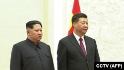A photo of Chinese President Xi Jinping (right) and North Korean leader Kim Jong Un in Beijing on March 27, 2018.