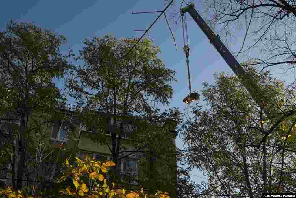 Рятувальники піднімають уламок російської ракети з житлового будинку.  Внаслідок російської атаки у Києві постраждали дві жінки  