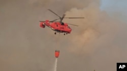 Vatrogasni helikopter gasi požar sjeveroistočno od Podgorice, glavnog grada Crne Gore, u utorak, 12. augusta 2025.