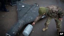 Украинский офицер демонстрирует термобарический заряд сбитого беспилотника «Шахед», который был запущен Россией. 14 ноября 2024 года