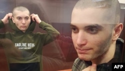 20-летний Салех Магамадов (справа) и 18-летний Исмаил Исаев стоят в стеклянной камере во время судебного заседания в Грозном