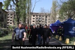 Міністр внутрішніх справ Ігор Клименко (у центрі) біля зруйнованого будинку в Святошинському районі, Київ, 24 квітня 2025 року