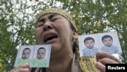 An ethnic Uzbek refugee shows photos of her missing grandsons on July 15.