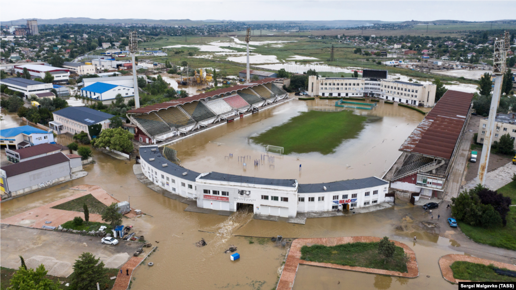 Вид на стадион имени 50-летия Октября, подтопленного из-за сильных дождей. Начальник отдела климата украинской общественной организации «Экодия» Евгения Засядько считает, что глобальное потепление приведет к резким изменениям погоды в Крыму. «Из-за выбросов парниковых газов, образующихся в результате сжигания ископаемого топлива, планета продолжает нагреваться. Это значит, что вода будет больше испаряться из того же Черного моря. Или у нас будет много дождей, или будут сильные засухи. К сожалению, они будут быстро сменяться и не будут компенсировать друг друга», – сказал эксперт