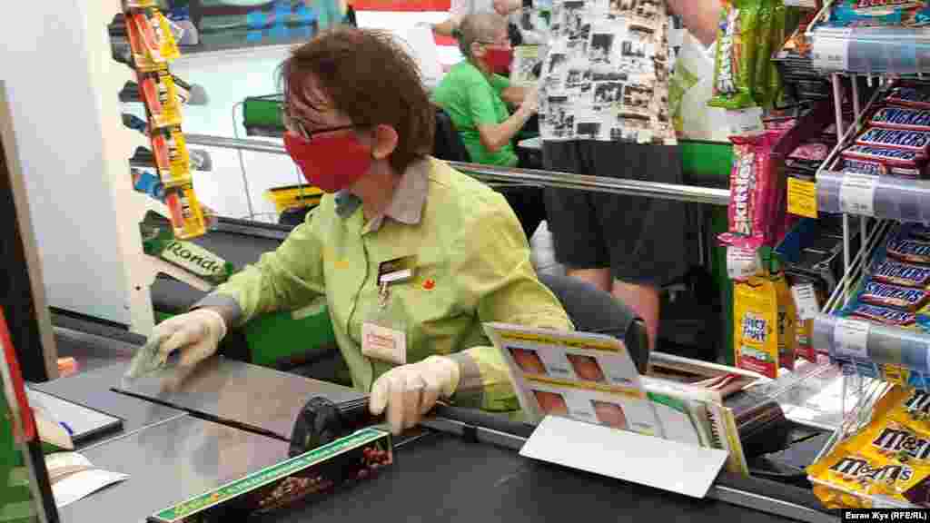 Продавці біля кас у торговому центрі – у захисних масках і рукавичках