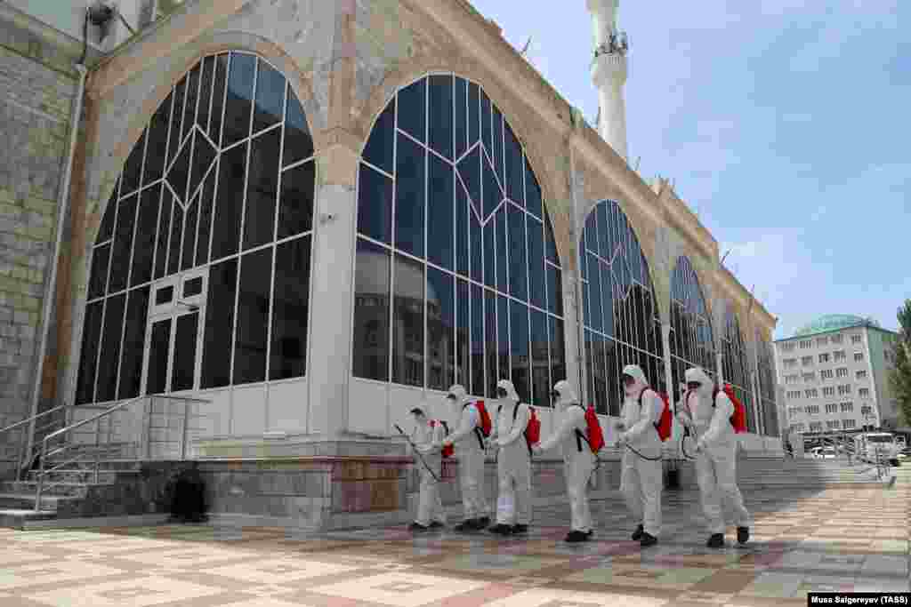 Sanitation crews disinfect the area outside the Djuma Mosque on May 21 in Makhachkala, the capital of the southern Russian region of Daghestan. Authorities have imposed restrictions to deter people from gathering in large groups this weekend, as the mostly Muslim-populated region marks Eid-al-Fitr, known locally as Uraza Bairam.