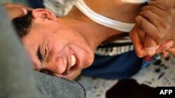 A young Libyan rebel, who was wounded by a sniper, is treated by medics in a makeshift clinic at a house close to the front line in Al-Ghiran, near Misurata airport, on April 29.