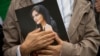  A portrait of Mahsa Amini is held during a rally calling for regime change in Iran following the death of Amini, a young woman who died after being arrested in Tehran by Iran's notorious morality police, in Washington, D.C., on October 1, 2022.