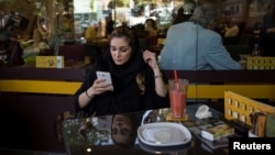An Iranian woman uses her mobile phone in a coffee shop in Tehran. (file photo)
