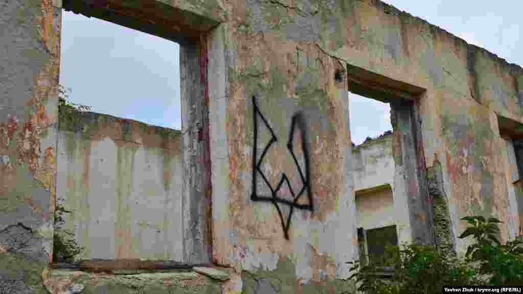 На руїнах будівлі колишньої військової частини намальований стилізований український герб – тризуб