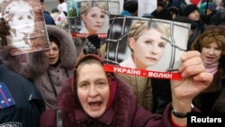 Supporters of jailed opposition leader Yulia Tymoshenko hold up her picture during a rally in Kyiv. The Tymoshenko case remains an obstacle to improved EU-Ukraine ties.