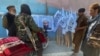Members of Taliban forces gather and look at a poster of their reclusive leader, Mullah Mawlawi Haibatullah Akhundzada, shortly after the militant group's takeover of Kabul in August.