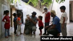 Мальчик примеряет самодельную газовую маску в Идлибе, Сирия, 3 сентября, 2018