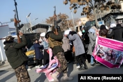 Taliban fighters fire guns into the air to disperse Afghan women during a protest in Kabul in December.