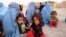 People who were displaced by fighting wait for government assistance at a temporary shelter in Herat Province on July 8.