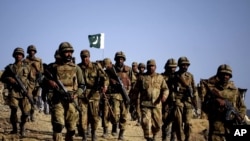 Pakistani troops walk on a hilltop post near Ladha, a town in the tribal region of South Waziristan in May 2011