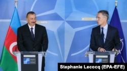 Azerbaijani President Ilham Aliyev (left) and NATO Secretary-General Jens Stoltenberg give a press conference at the end of a meeting at NATO headquarters in Brussels on November 23.
