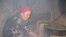 A Tajik woman cooks food over an open fire due to lack of electricity.