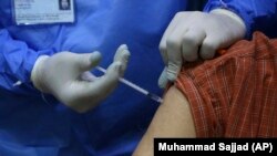 پېښورکې یوه کس ته د کورونا واکسین لګول کېږي