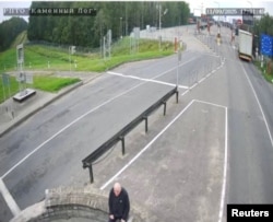 A man, believed to be Belarusian opposition politician Mikalay Statkevich, sits in the no man's zone at the Lithuania border crossing on September 11.