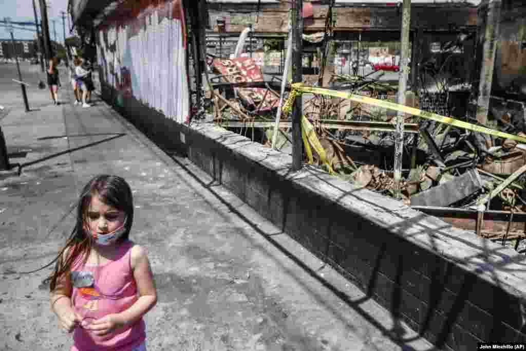 Дівчинка біля зруйнованої та пограбованої алкогольної крамниці в Міннеаполісі