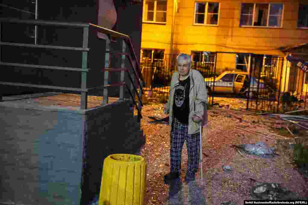 O persoană în vârstă și cu dificultăți în a se deplasa încearcă să se pună la adăpost la scurt timp după ce clădirea în care locuia a fost afectată de atacurile rusești.