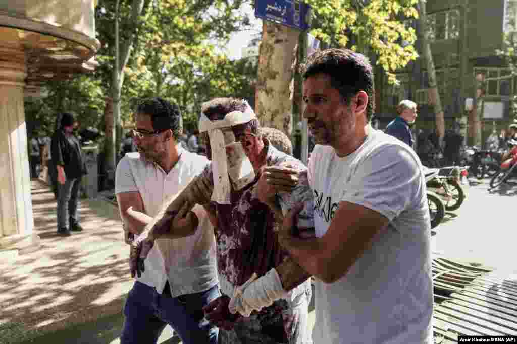 Iran, 15 iunie 2025. Un bărbat rănit este îndepărtat de la locul unei explozii în centrul Teheranului.