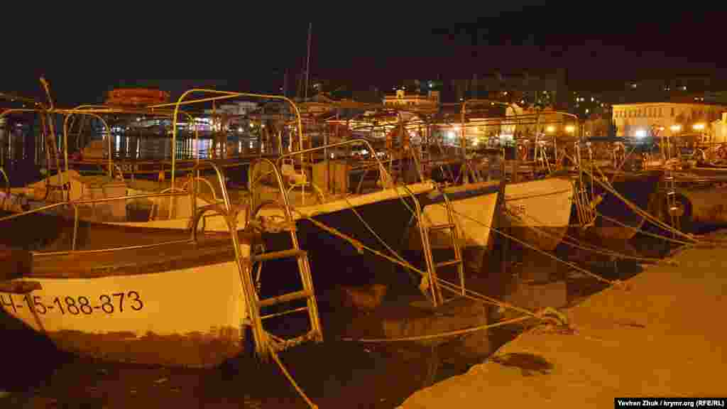 Прогулянкові ялики «припарковані» біля набережної, вони чекають початку літнього сезону