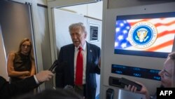 Președintele american Donald Trump vorbește cu reporterii la bordul Air Force One, în zbor, pe 15 august 2025, în drum spre Anchorage.