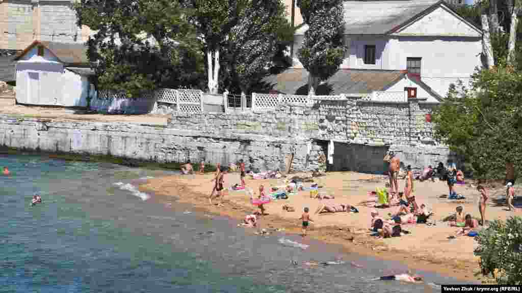 Невеликий піщаний пляж поруч з офіційним бетонним пляжем «Ушакова балка» в Нахімовському районі Севастополя. Місцеві жителі називають його пляжем «Вугільна бухта»