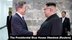 South Korean President Moon Jae-in (left) shakes hands with North Korean leader Kim Jong Un during their summit in the truce village of Panmunjom, North Korea on May 26.