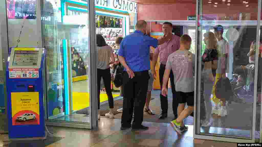 Охоронець не пропускає людей без масок до торгового центру «Мусон»