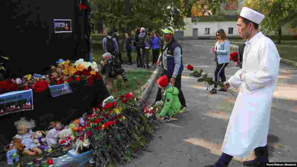 Рядом с учебным заведением установили импровизированный мемориал – черное полотно с фотографиями свечей и надписью «скорбим»