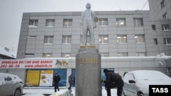 Рабочий отмывает памятник Ленину в Новосибирске, ранее раскрашенный в цвета украинского флага