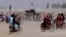 PAKISTAN -- Supporters of the Taliban carry the Taliban's signature white flags in the Afghan-Pakistan border town of Chaman, Pakistan, Wednesday, July 14, 2021.