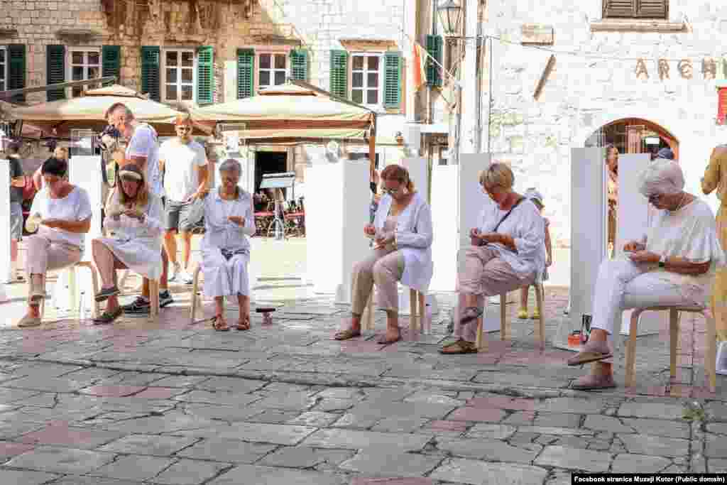 Na jednom od trgova u kotorskom Starom gradu polaznice muzejske radionice izrađuju minijature od dobrotske čipke.