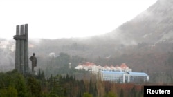 На фотографии 2009 года изображена часть пионерского лагеря «Артек» и памятник Владимиру Ленину на Южном побережье Крыма